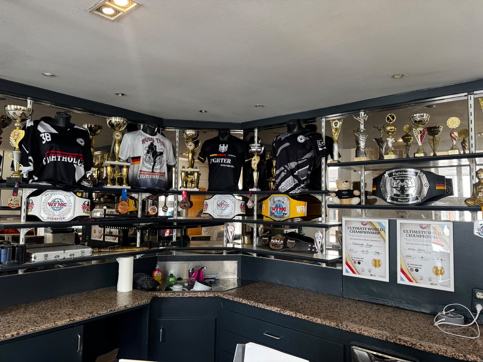 Pokale, Meisterschaftsgürtel und Urkunden im Fightholics Gym